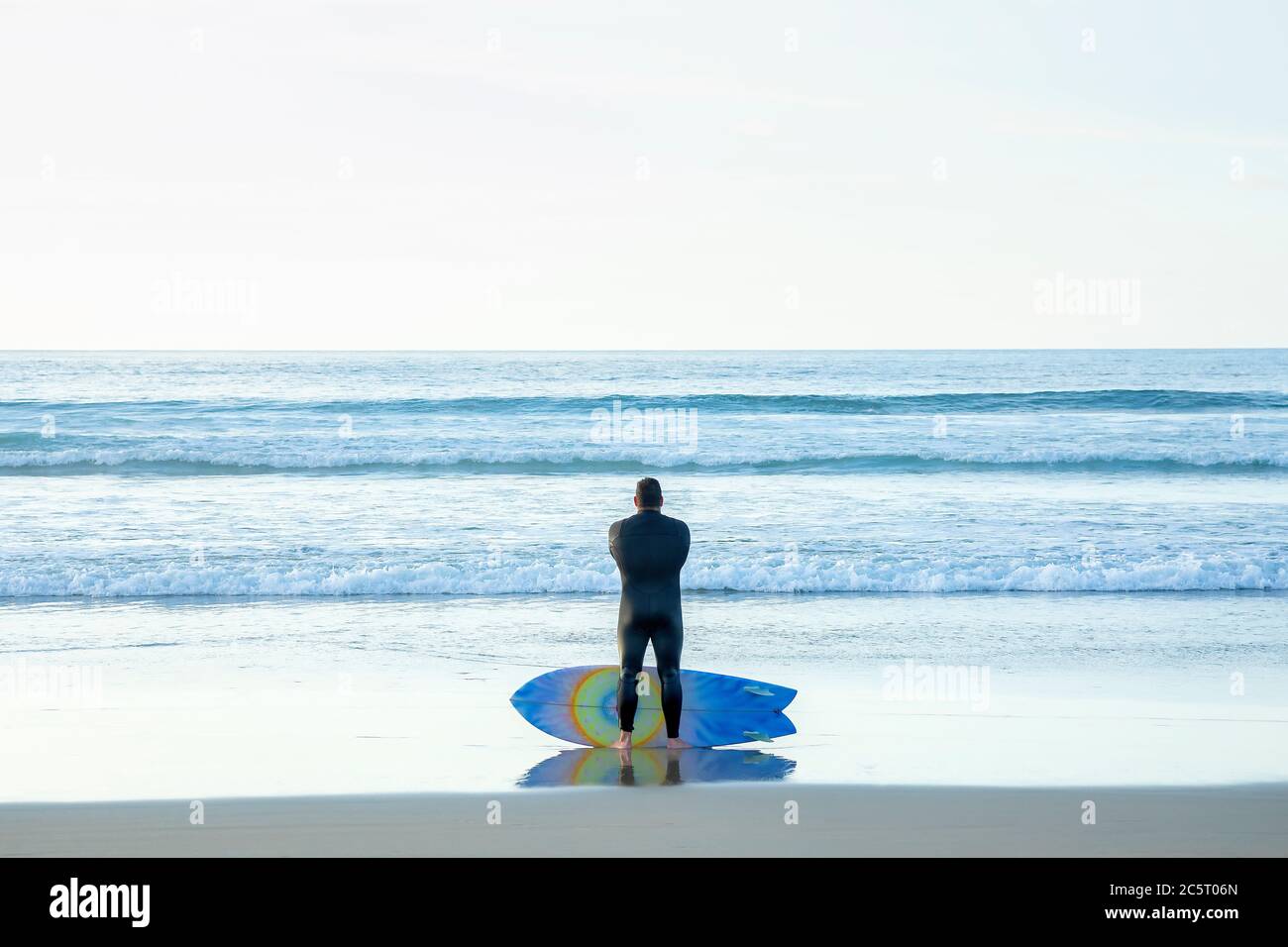A male surfer contemplating the ocean in La Jolla, California Stock Photo