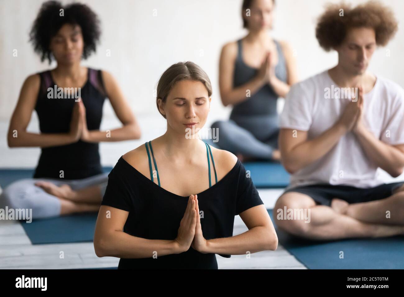 Young mindful concentrated woman practicing breathing yoga exercises ...