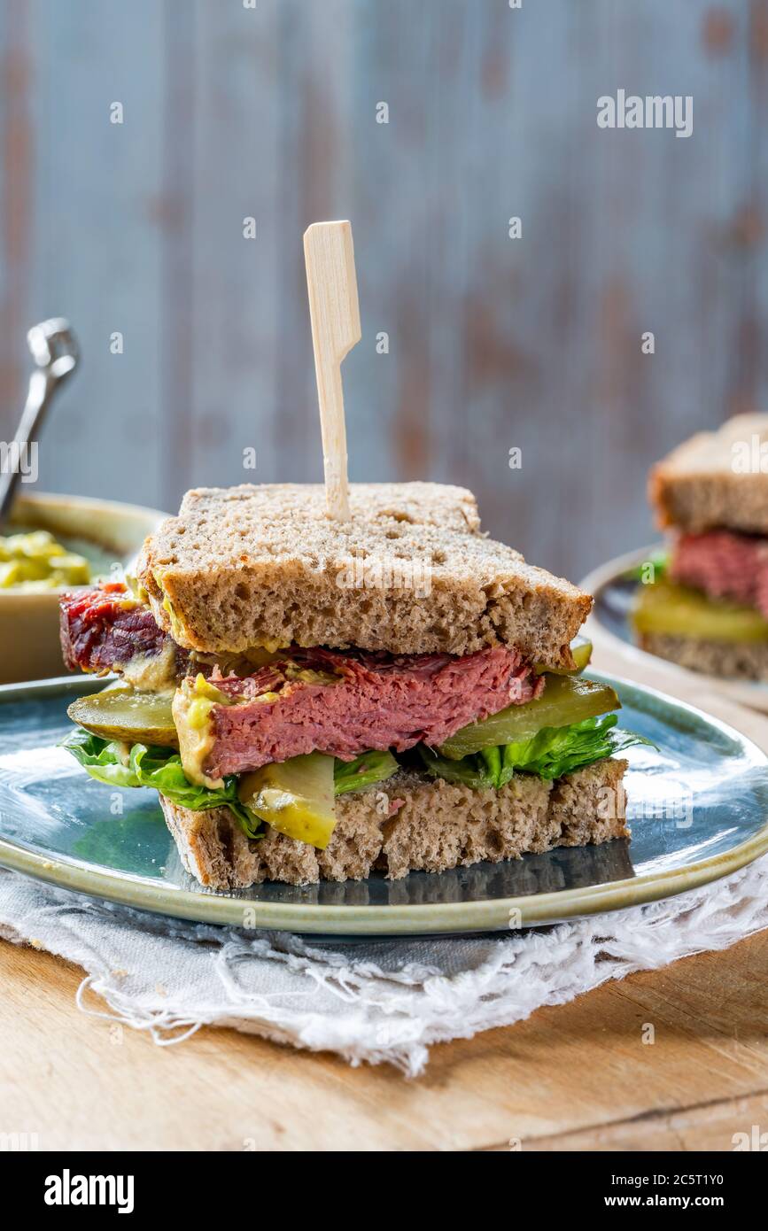 Salt beef sandwich with pickled cucumber and mustard tartar sauce Stock