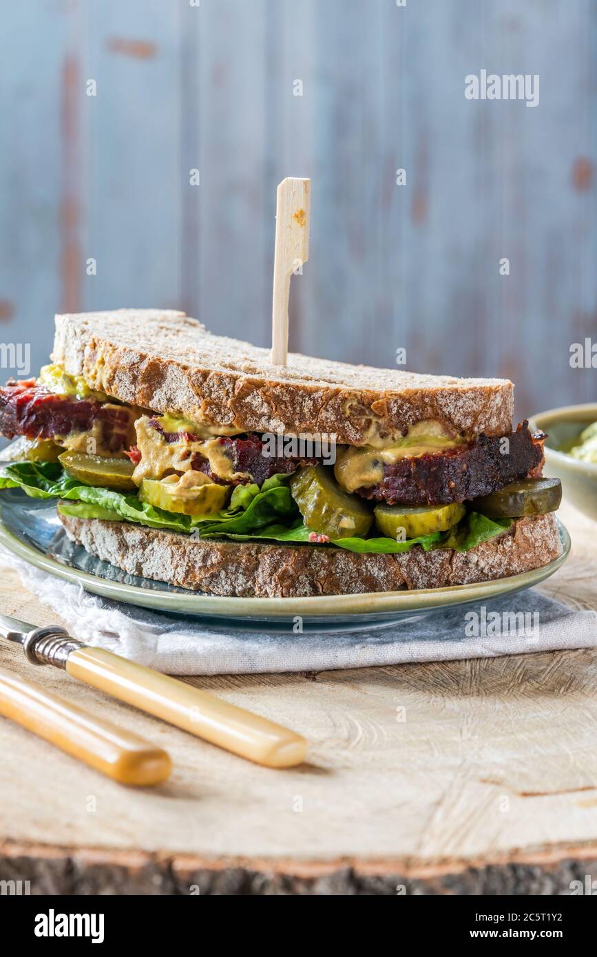 Salt beef sandwich with pickled cucumber and mustard tartar sauce Stock