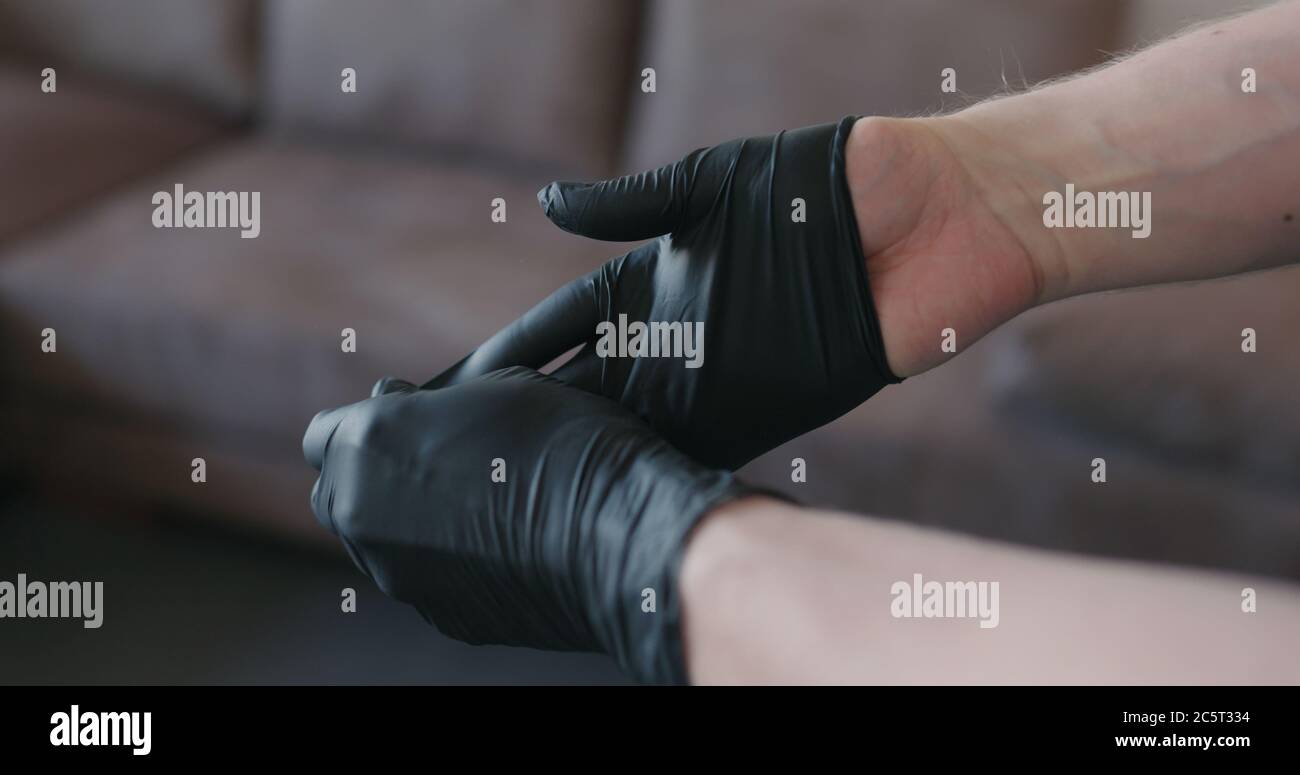man hands takes off black nitrile protective gloves indoors Stock Photo Alamy