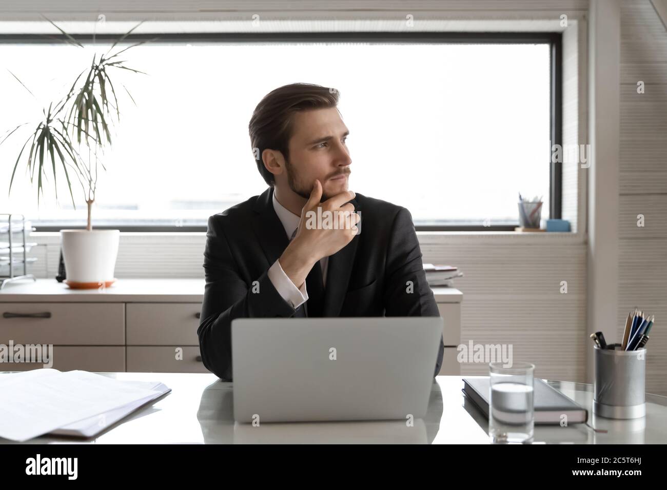 Pensive businessman distracted from computer work thinking in office Stock Photo