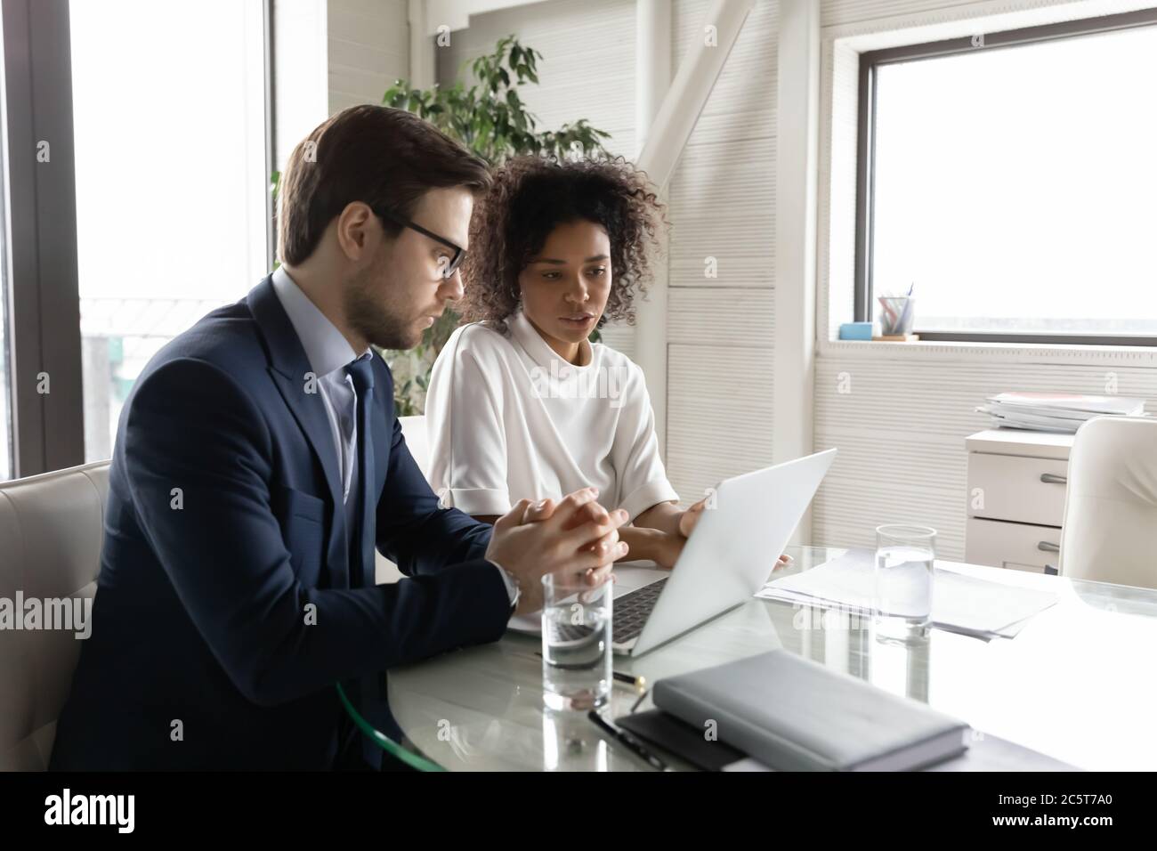 Multiethnic diverse colleagues brainstorm using laptop at briefing Stock Photo