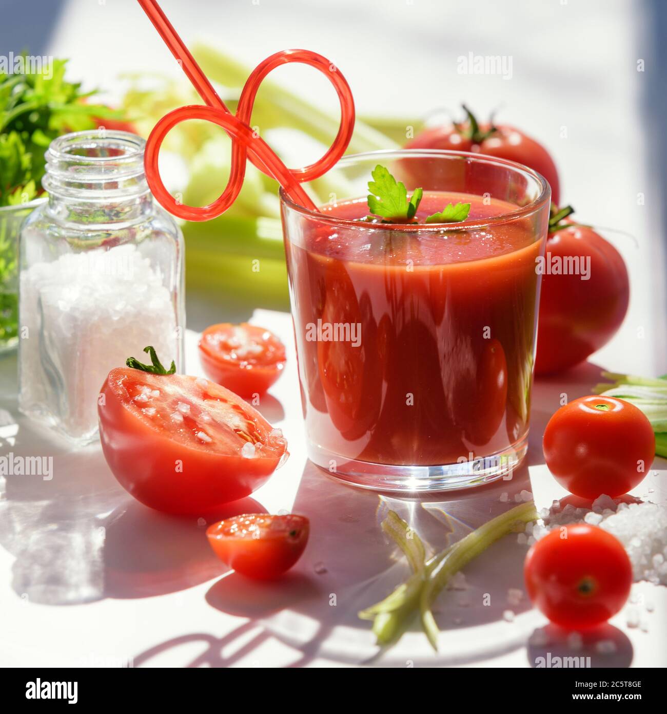 Tomato juice in glass with celery, cherry tomato, white wood background, closeup Stock Photo