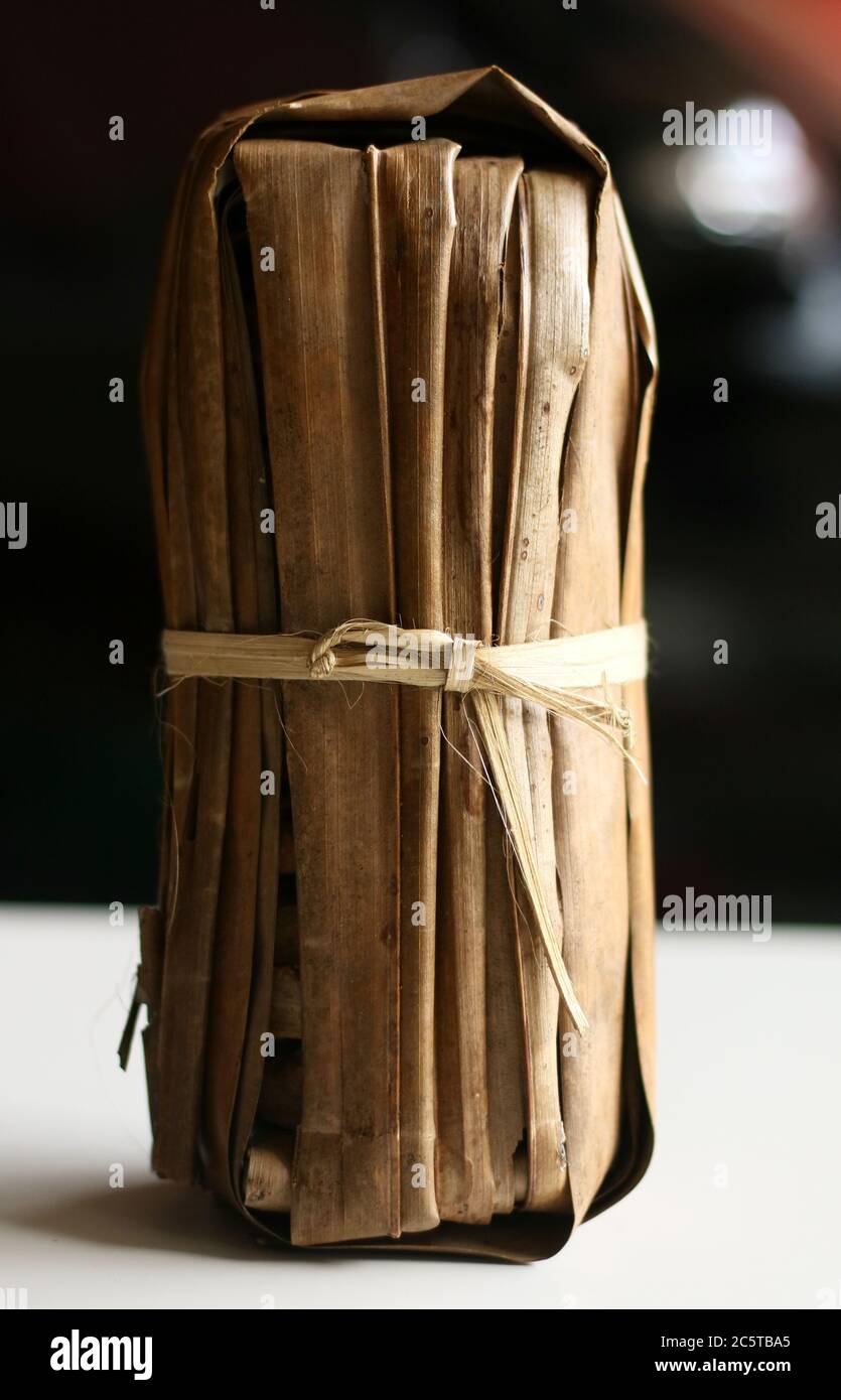 Traditional brown sugar or palm sugar from Ciamis, West Java, Indonesia. Wrapped in palm leaves. Stock Photo