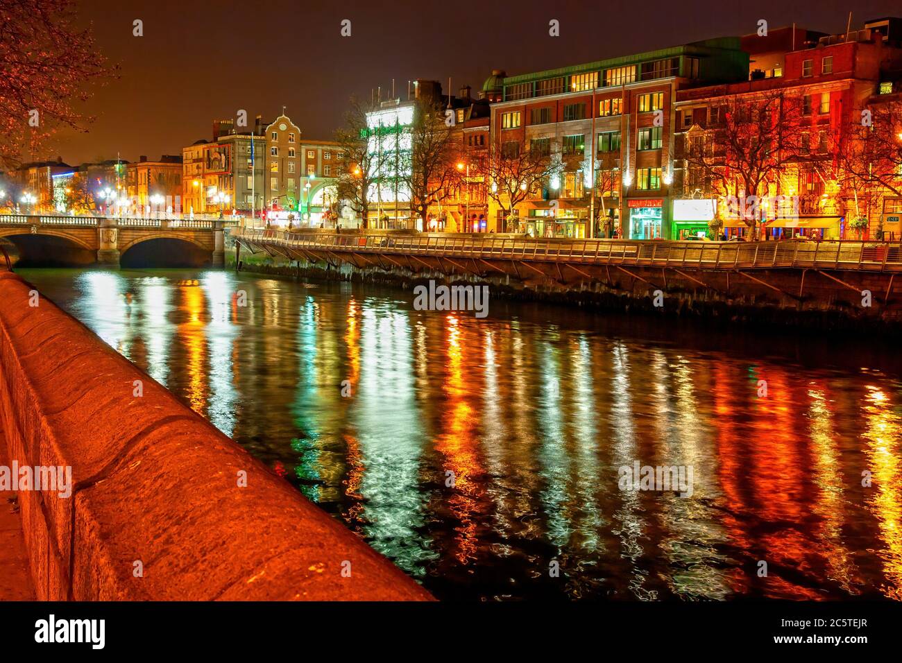 Dublin by night in Ireland, city lights reflections in River Liffey