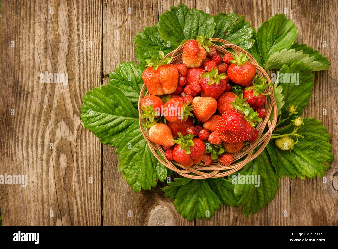 Ripe, juicy and red, strawberry in a plate close-up, on a wooden background. Stock Photo
