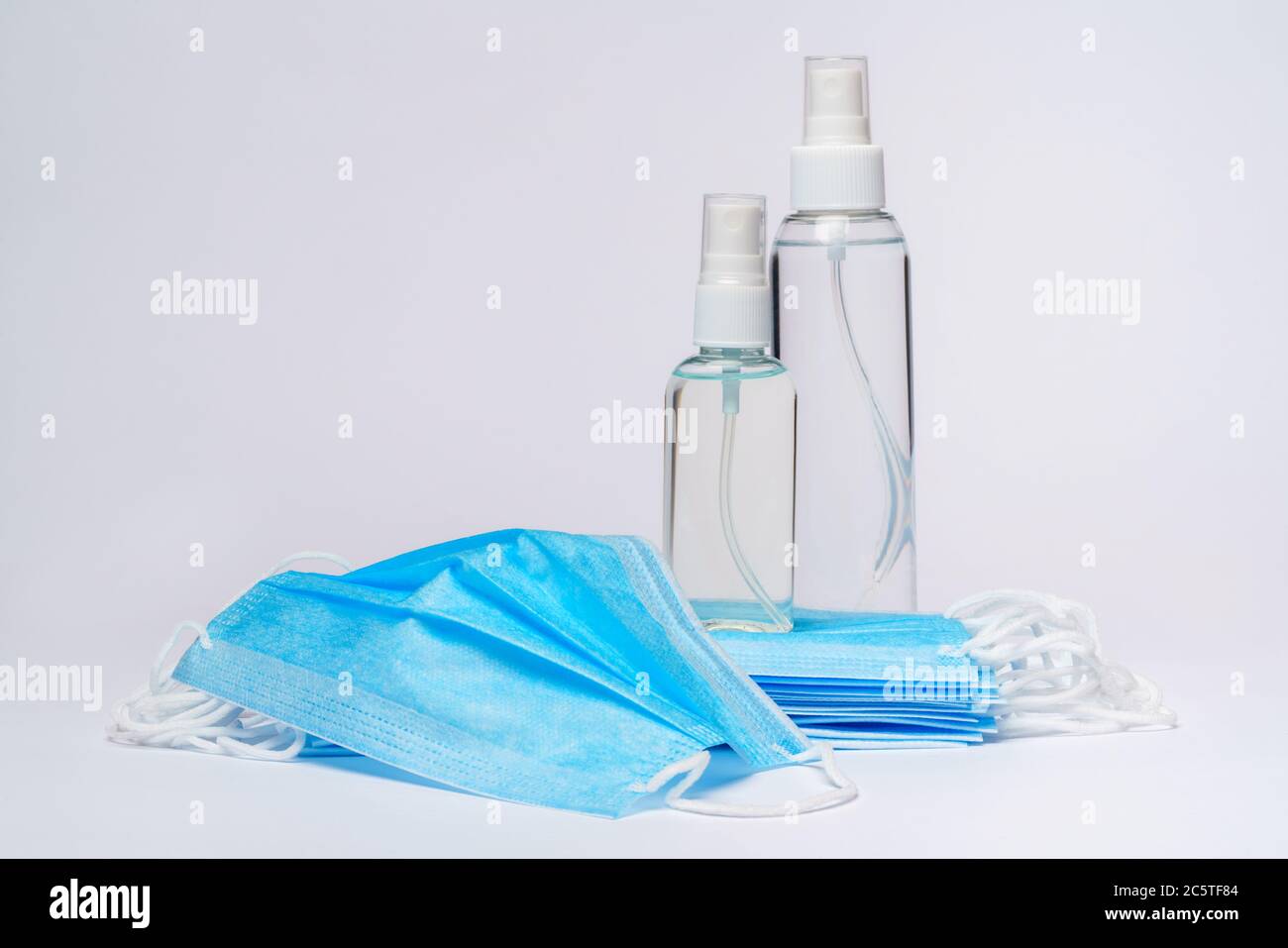bottle of lotion, sanitizer or liquid soap and protective mask over ...