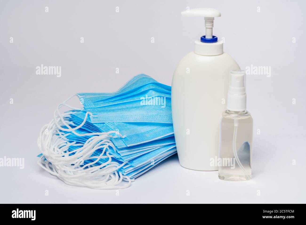 bottle of lotion, sanitizer or liquid soap and protective mask over ...
