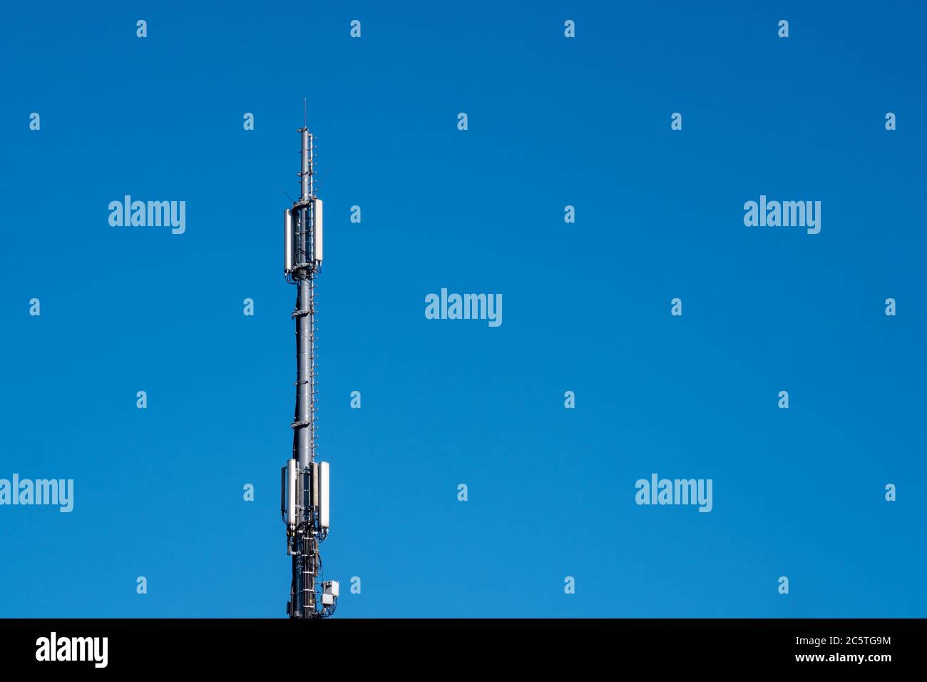 Mobile radio mast in front of blue sky Stock Photo