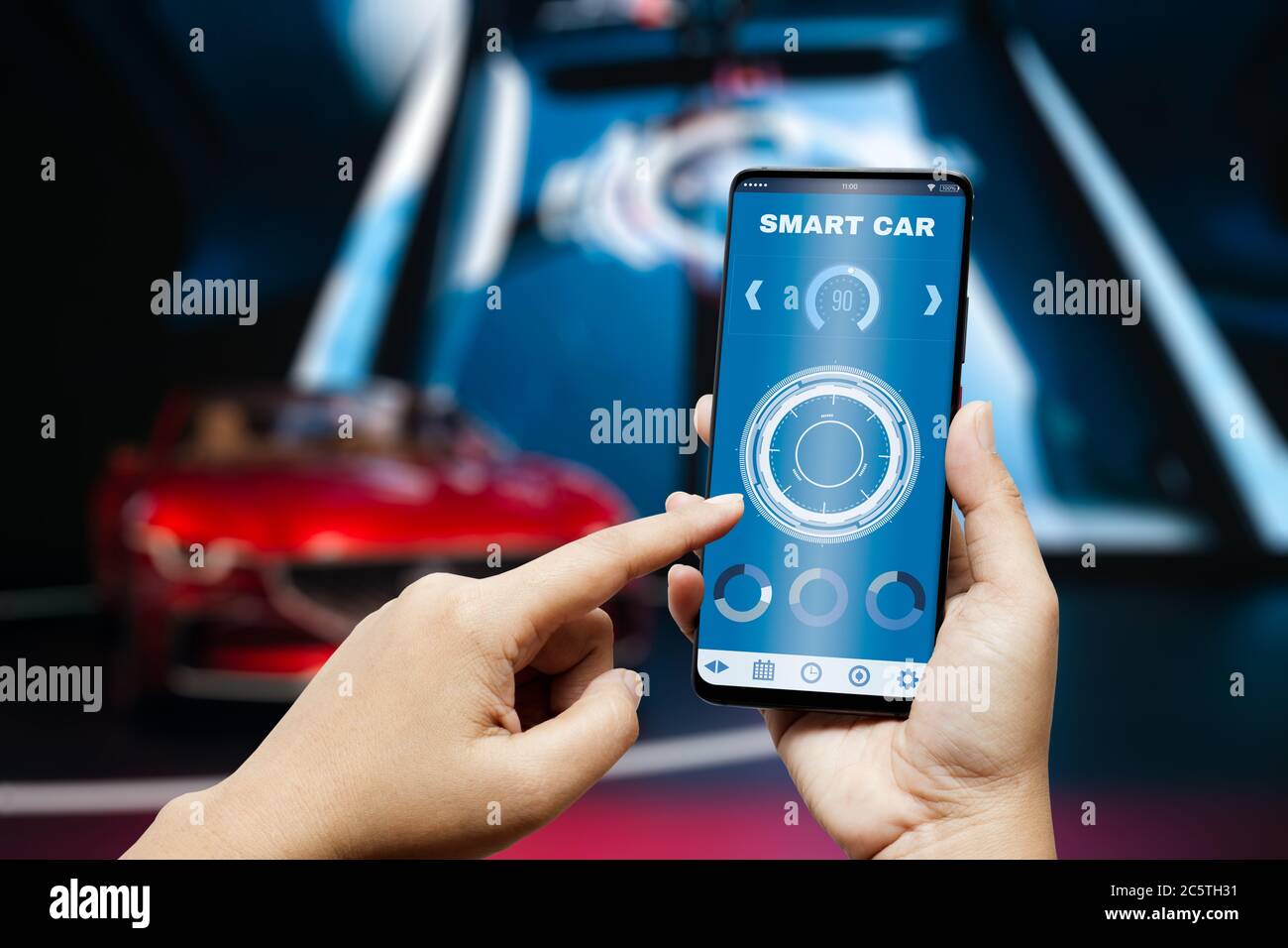 Smart car appliction background concept. Hand holding smart phone and application dashboard with blurred sport car as background. Internet of things I Stock Photo