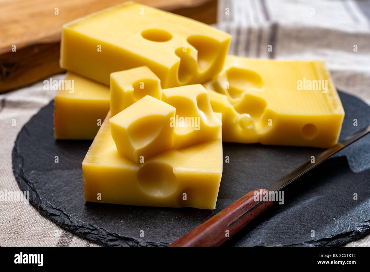 Block of Swiss mediumhard yellow cheese emmental or emmentaler with round holes and cheese