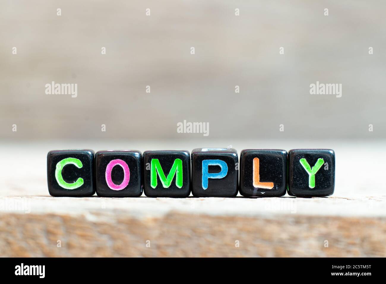 Black bead with color letter in word comply on wood background Stock ...