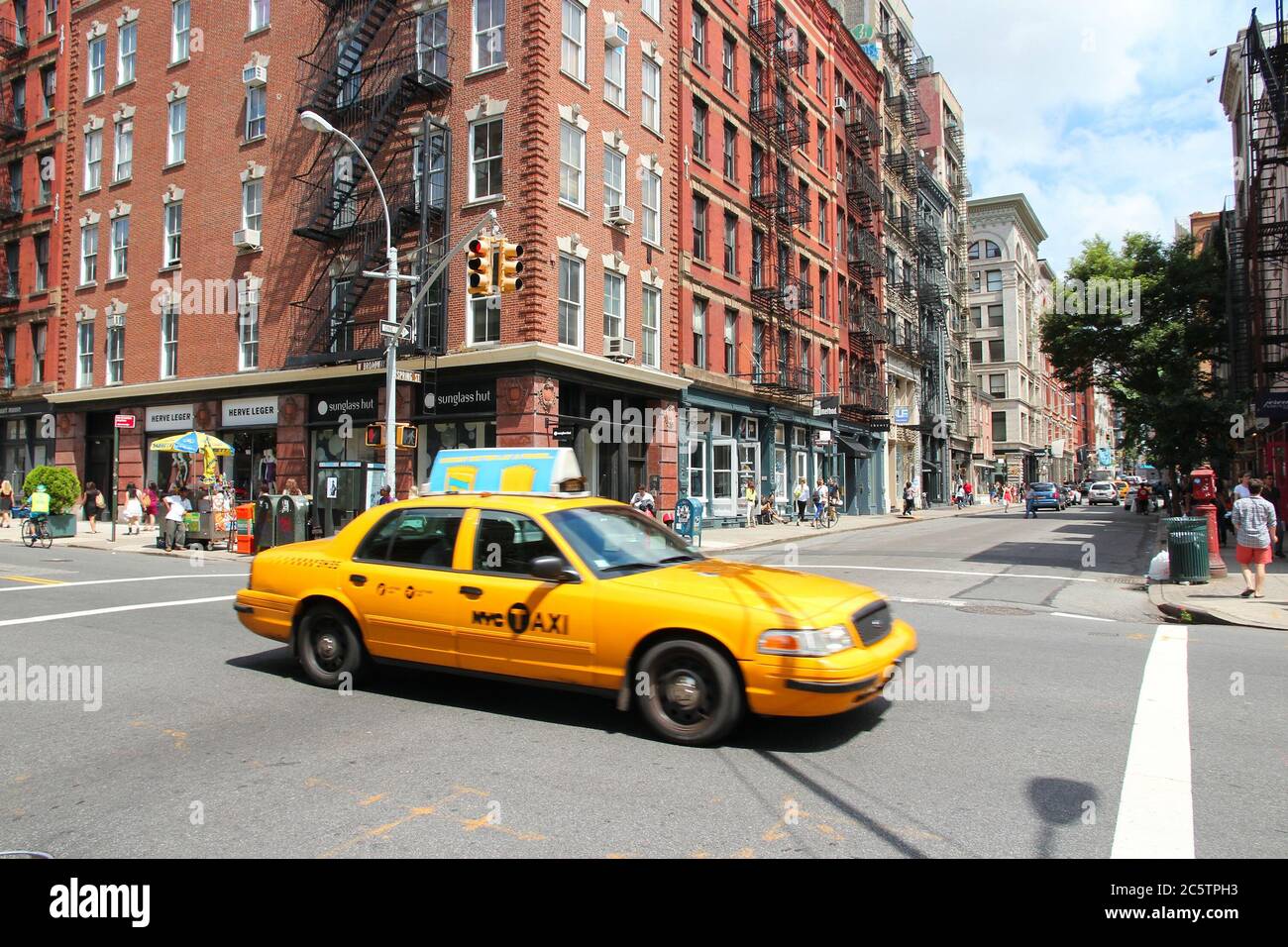 NEW YORK, USA - JULY 2, 2013: People ride yellow taxi cab in SoHo, New York. As of 2012 there were 13,237 yellow taxi cabs registered in New York City Stock Photo