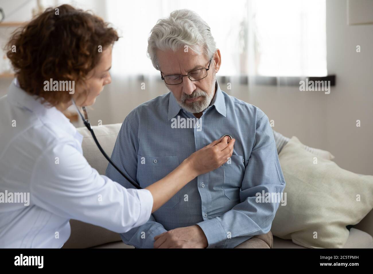 Caring female doctor listen to heart of mature patient Stock Photo - Alamy