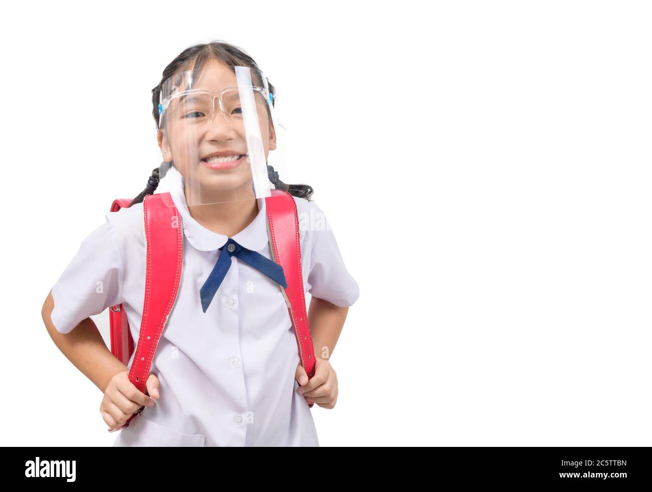 Cute girl student wearing face shield and carries school bag isolated on white background. against and  prevent corona virus covid 19 and new normal e Stock Photo