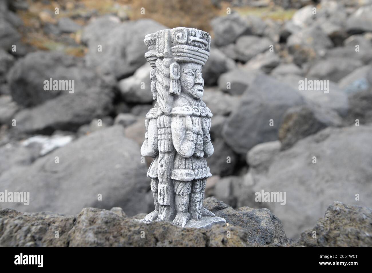 Ancient Maya Statue on the Rocks near the Ocean Stock Photo