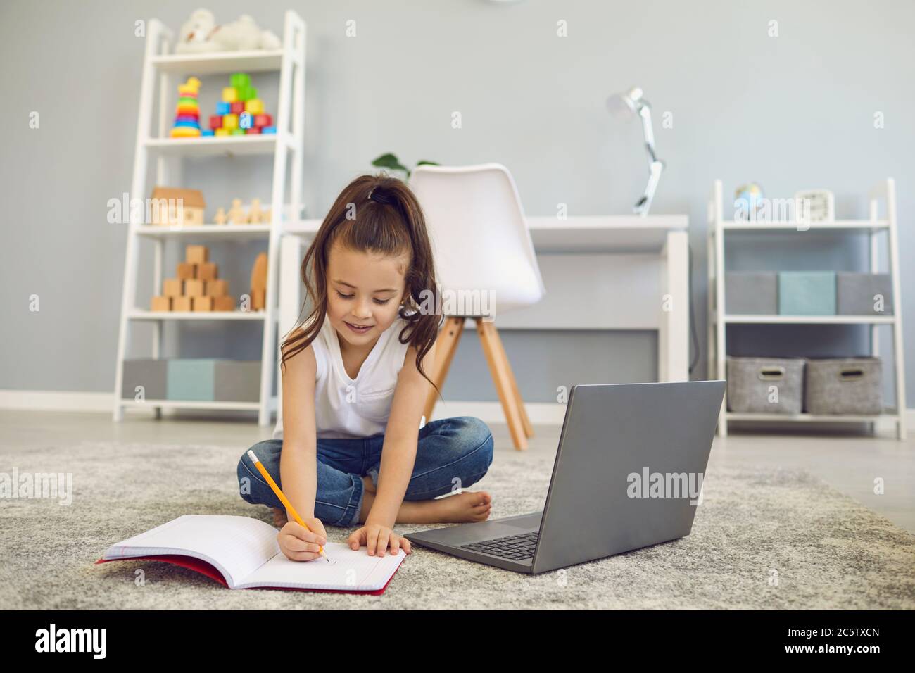 Online education of children. A little girl does a teacher lesson from ...