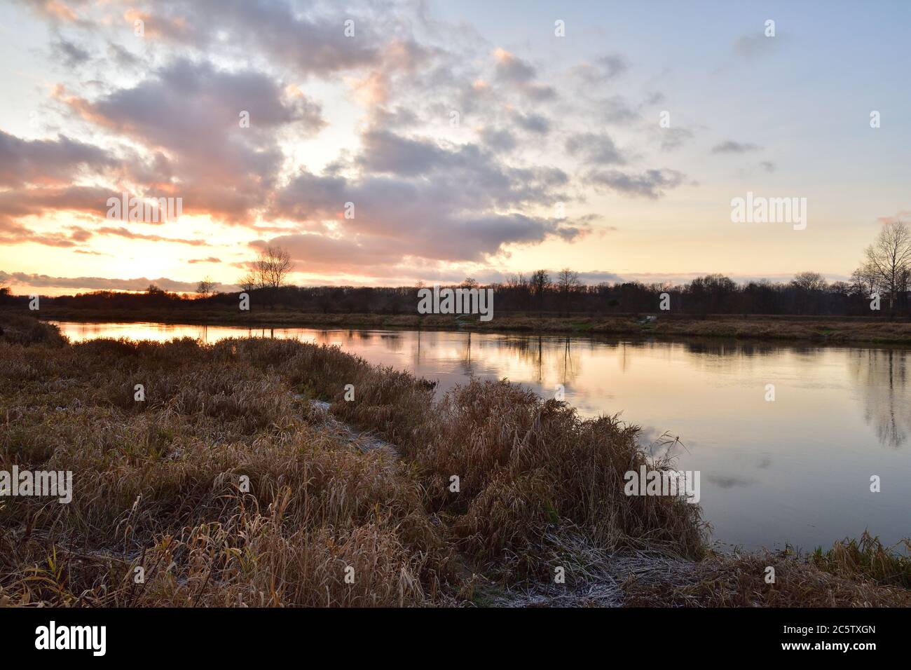 Sunset over a wide river on a cool spring day. Fish eye lens. Spring. Stock Photo