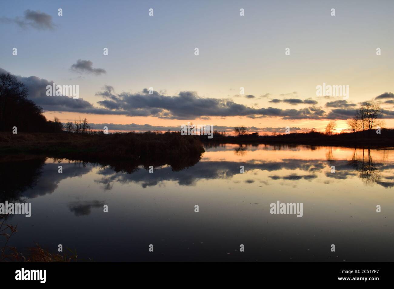 Sunset over a wide river on a cool spring day. Fish eye lens. Spring. Stock Photo