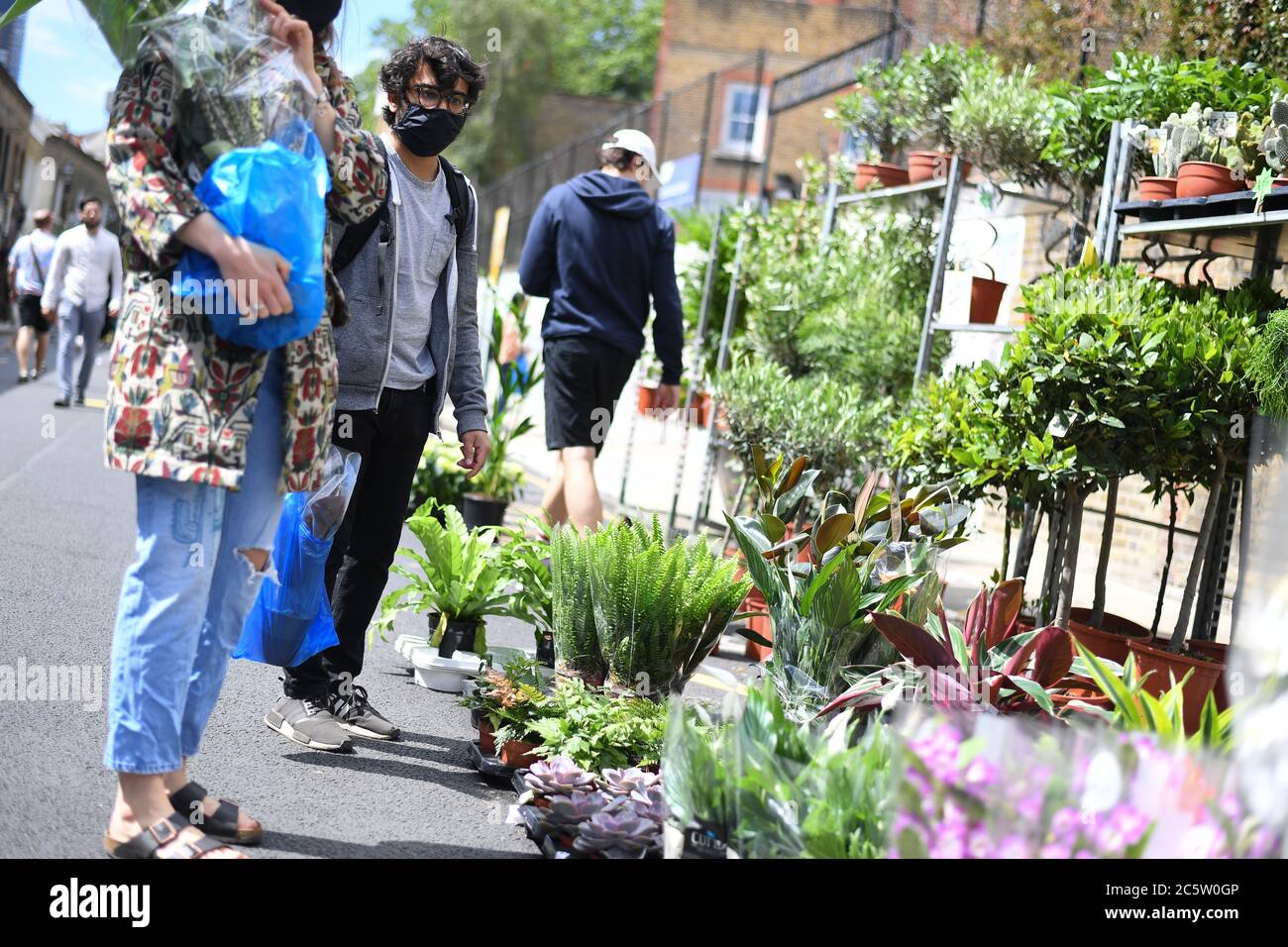 A man browses at Columbia Road Flower Market, London, as it reopens following the easing of coronavirus lockdown restrictions across England. Stock Photo