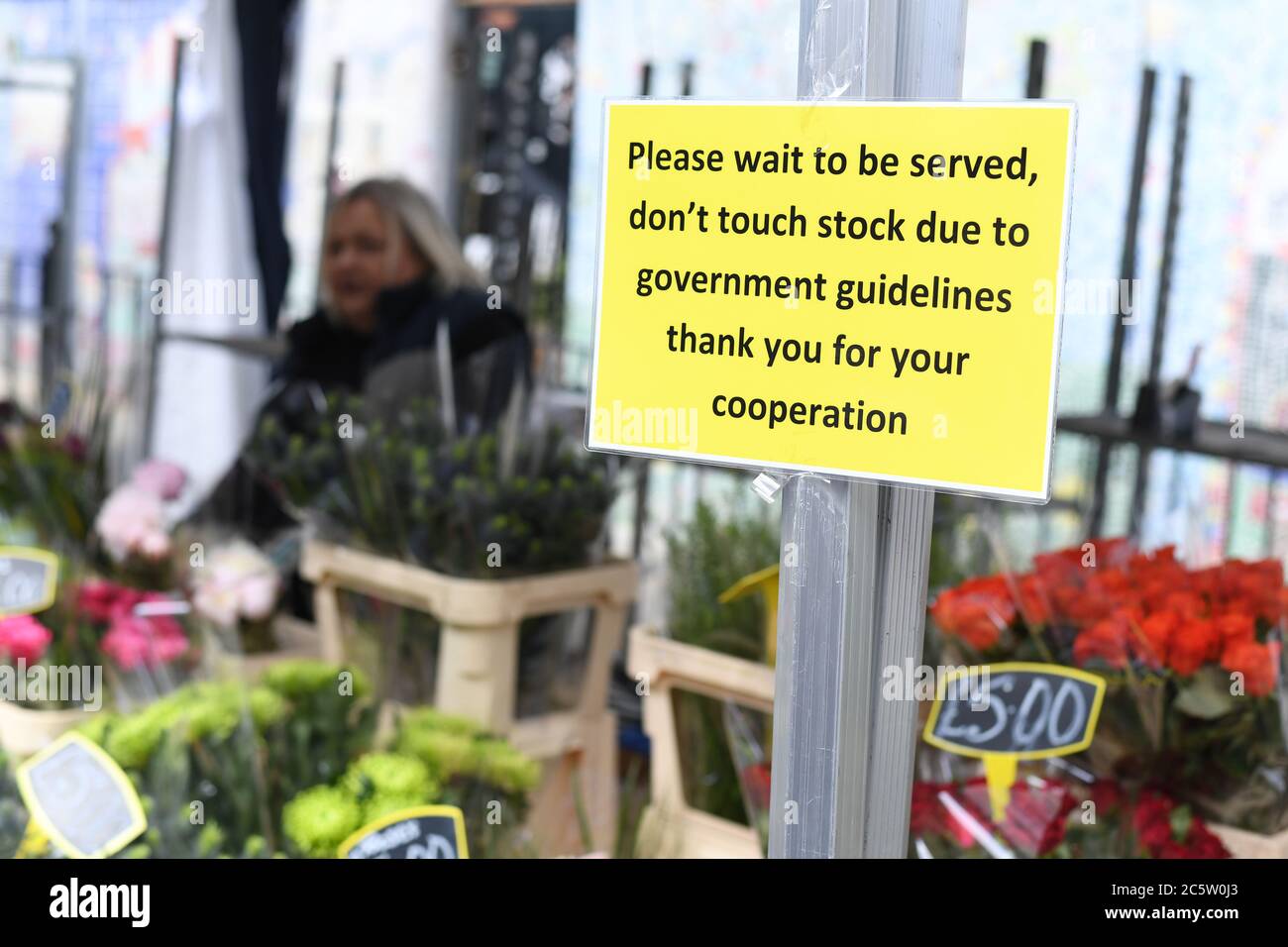 A sign advising customers not to touch stock at Columbia Road Flower Market, London, as it reopens following the easing of coronavirus lockdown restrictions across England. Stock Photo