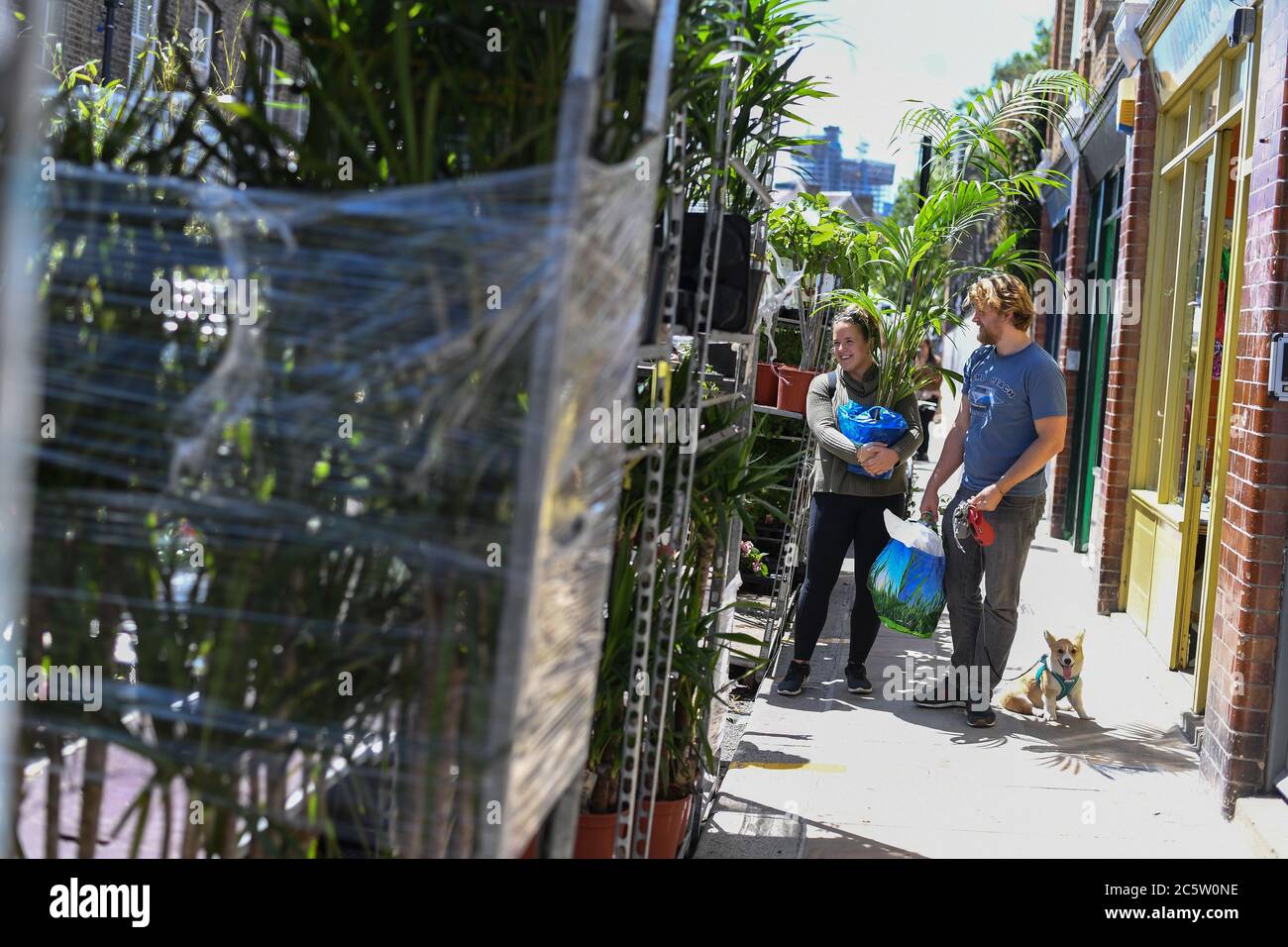 People visit Columbia Road Flower Market, London, as it reopens following the easing of coronavirus lockdown restrictions across England. Stock Photo