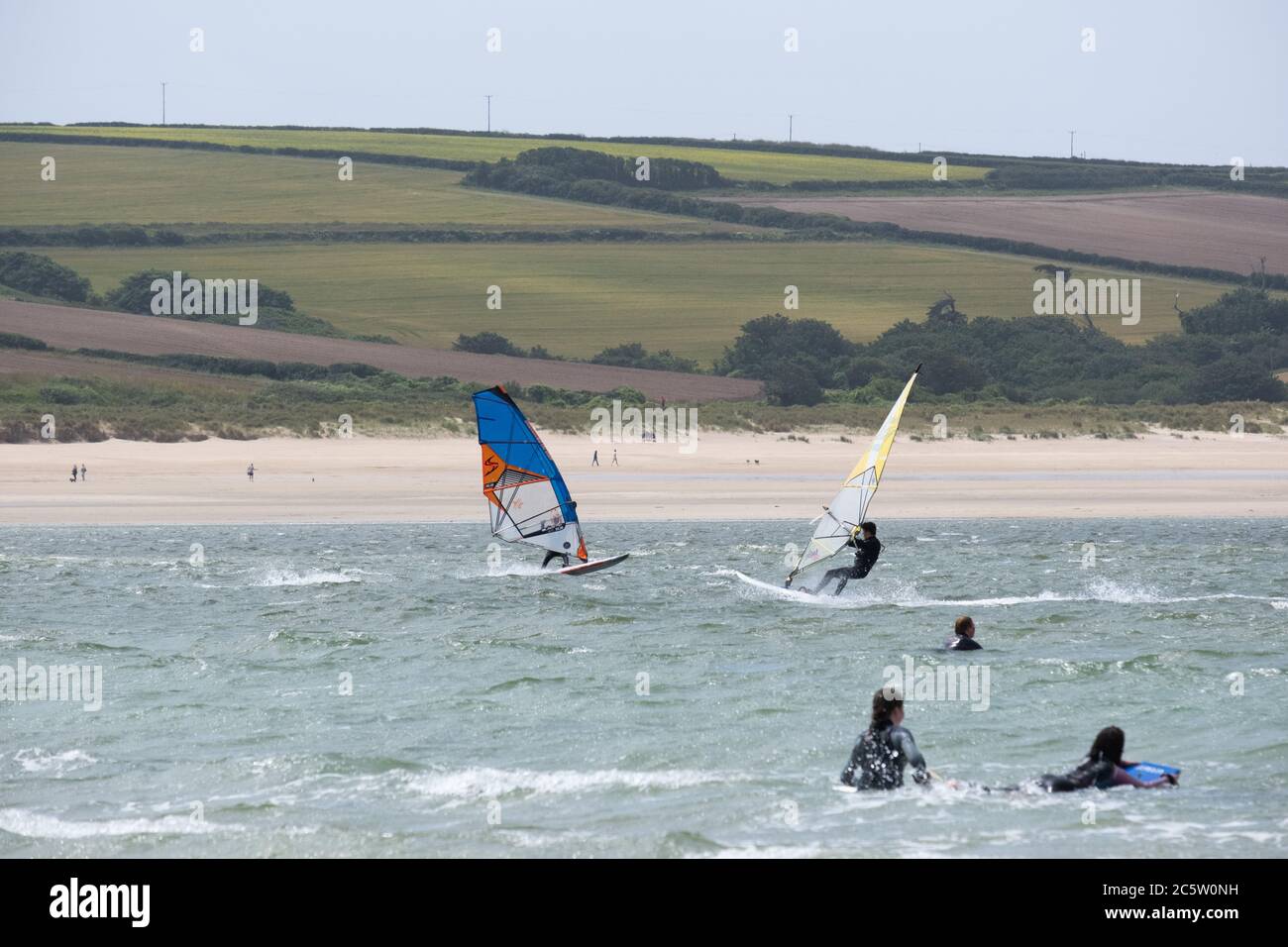 Daymer Bay, Rock, Cornwall, UK. 5th July 2020. UK Weather. A strong wind didn't keep people off the beach at Daymer bay this lunchtime. Ideal weather for a spot of windsurfing. Credit CWPIX /  Alamy Live News. Stock Photo