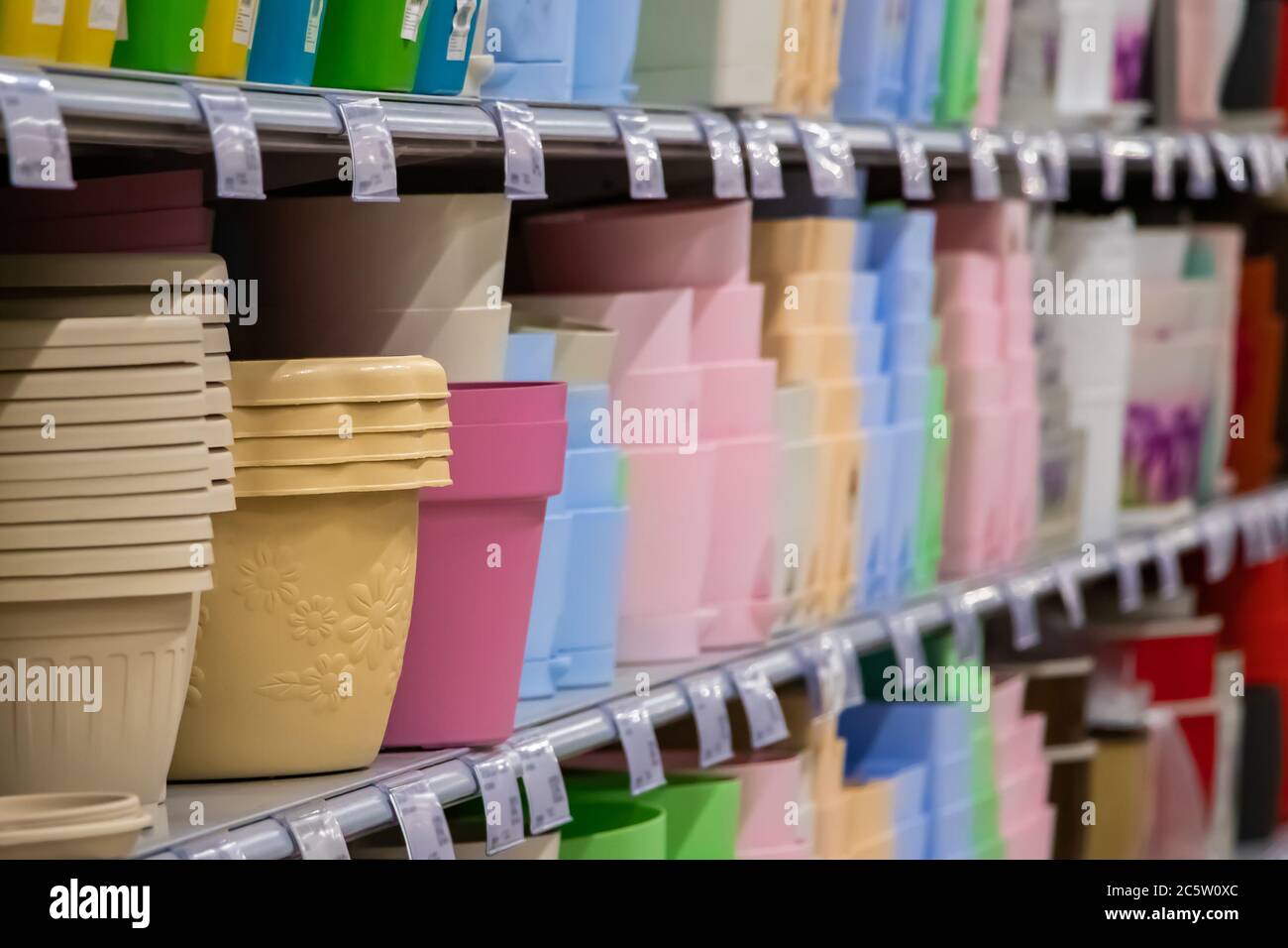 Pots for home plants on shelves in a flower shop. Spring planting of seeds. Stock Photo