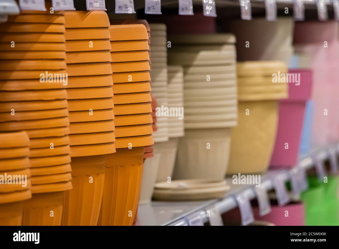 Pots for home plants on shelves in a flower shop. Spring planting of seeds. Stock Photo