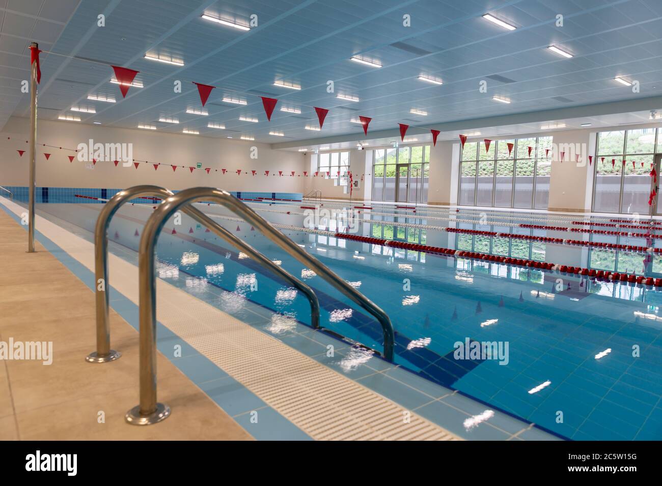 Indoor swimming pool full of water with ladder on the side Stock Photo ...