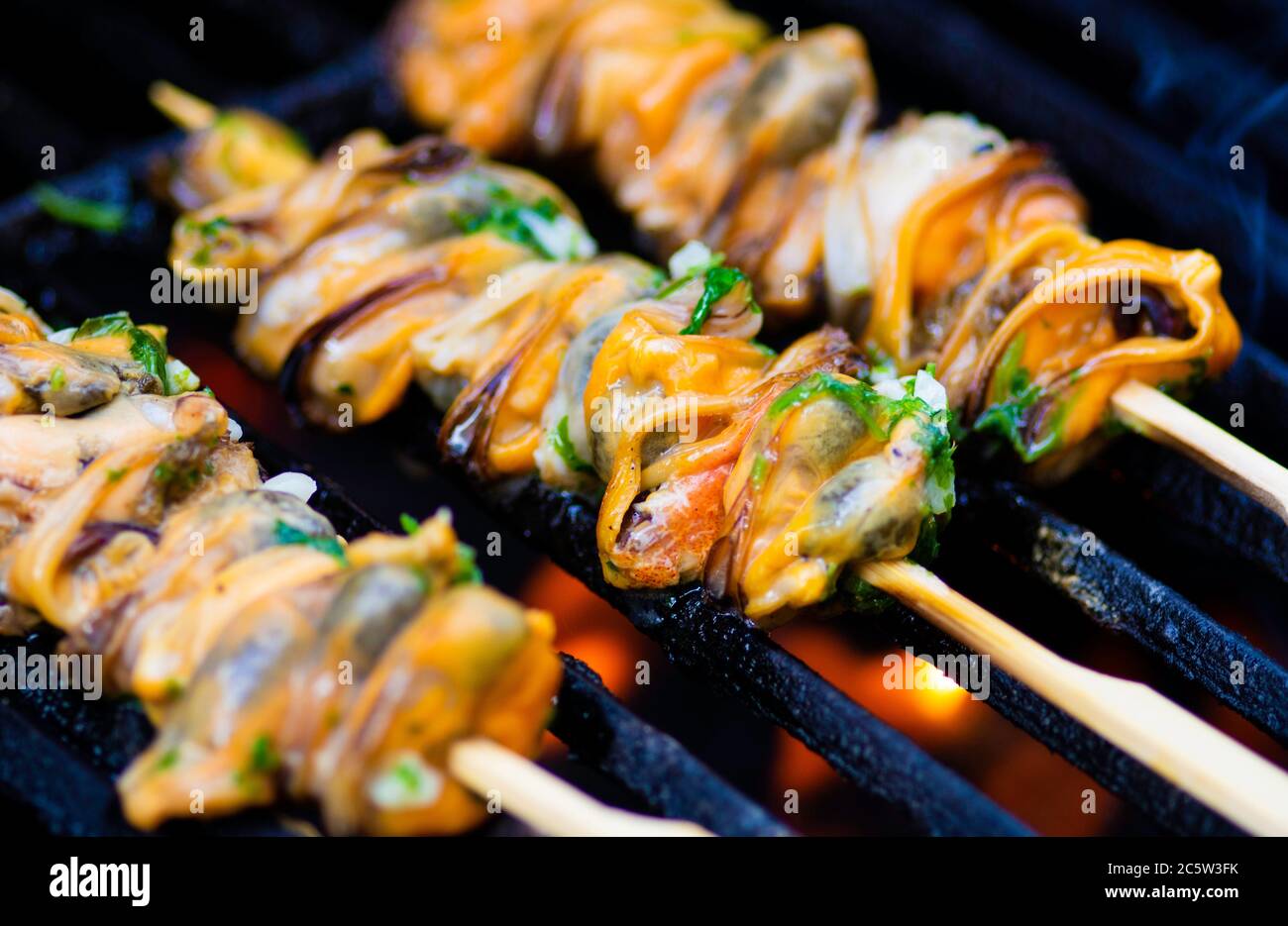 Skewered Garlic Mussels cooked on a Barbecue Stock Photo