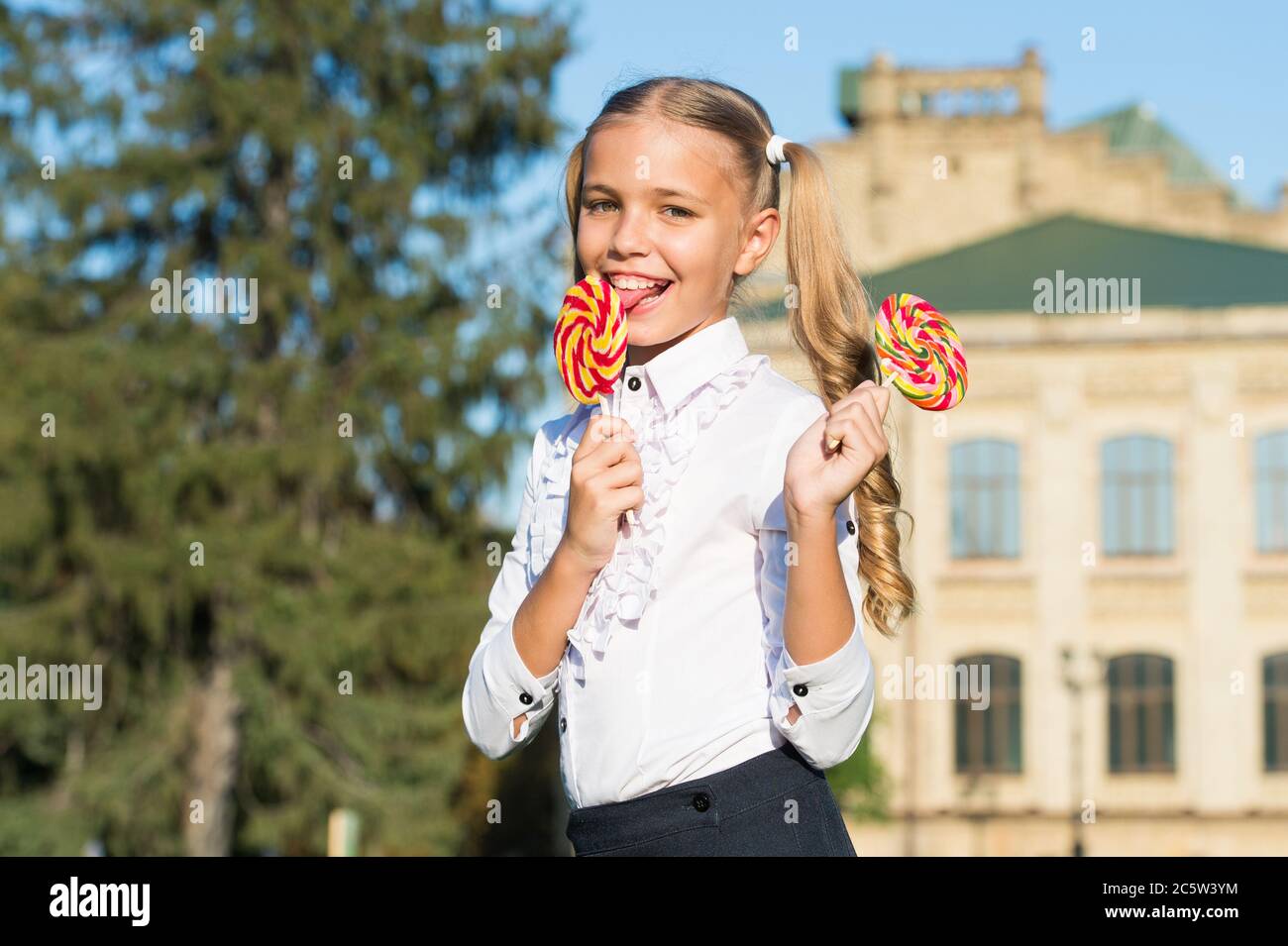 Candy makes mouth happy. Little girl lick candy sunny outdoors. Candy shop. Lollipop or sucker. Sugary treat. Confectionary. Food and snack. Sweet world. You deserve a candy today. Stock Photo