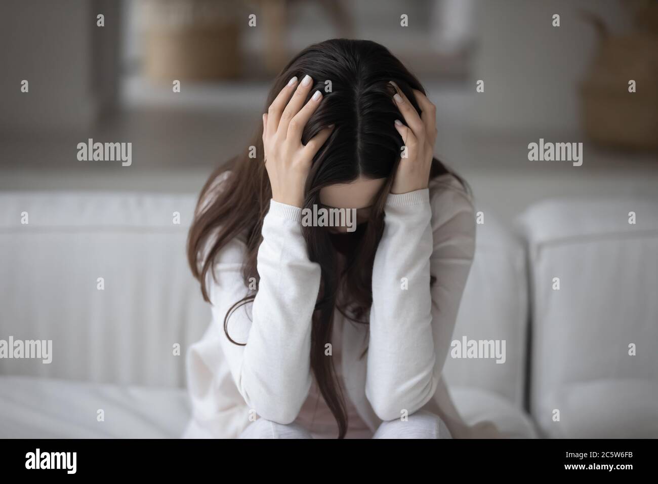Close up hopeless unhappy young woman holding head, feeling depressed Stock Photo