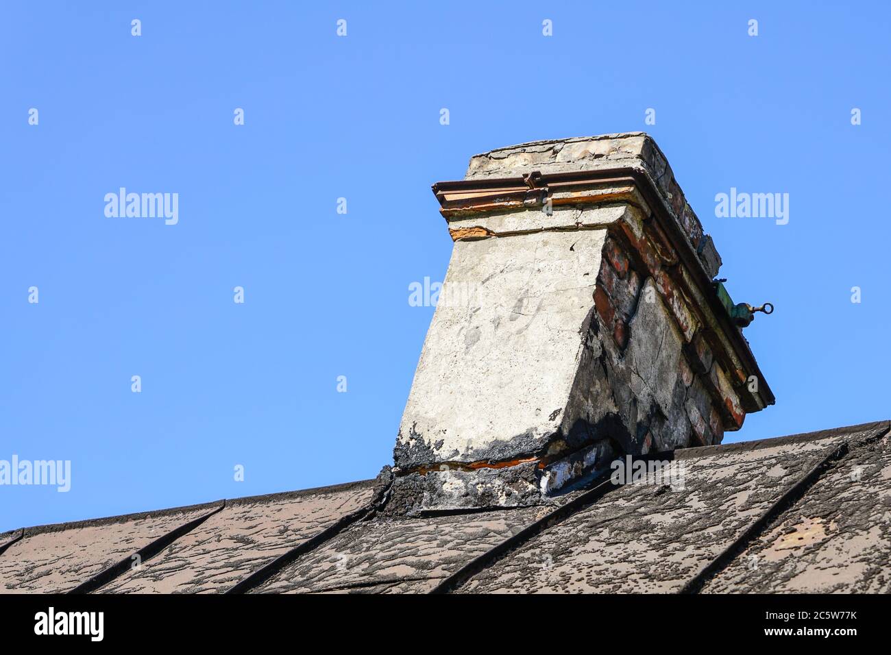 damaged brick chimney, cracked and dangerously skewed Stock Photo