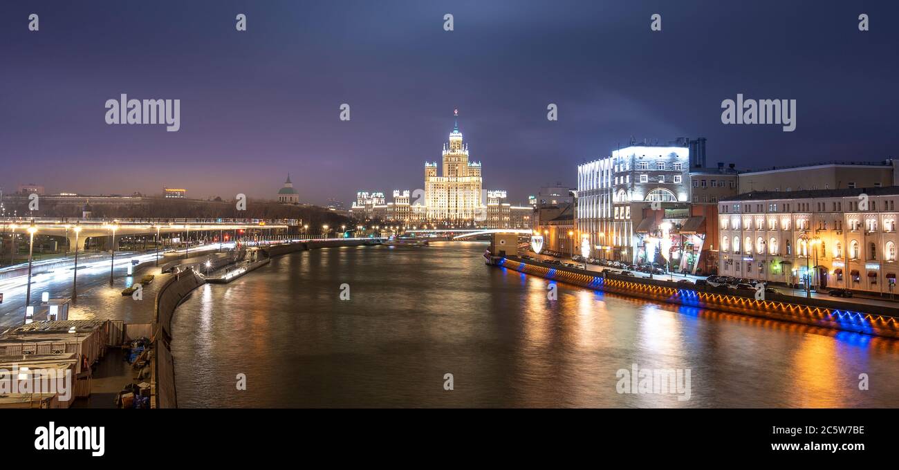 Moscow, Russia. View of illuminated Stalin skyscraper Kotelnicheskaya embankment building and Moskva River at night Stock Photo