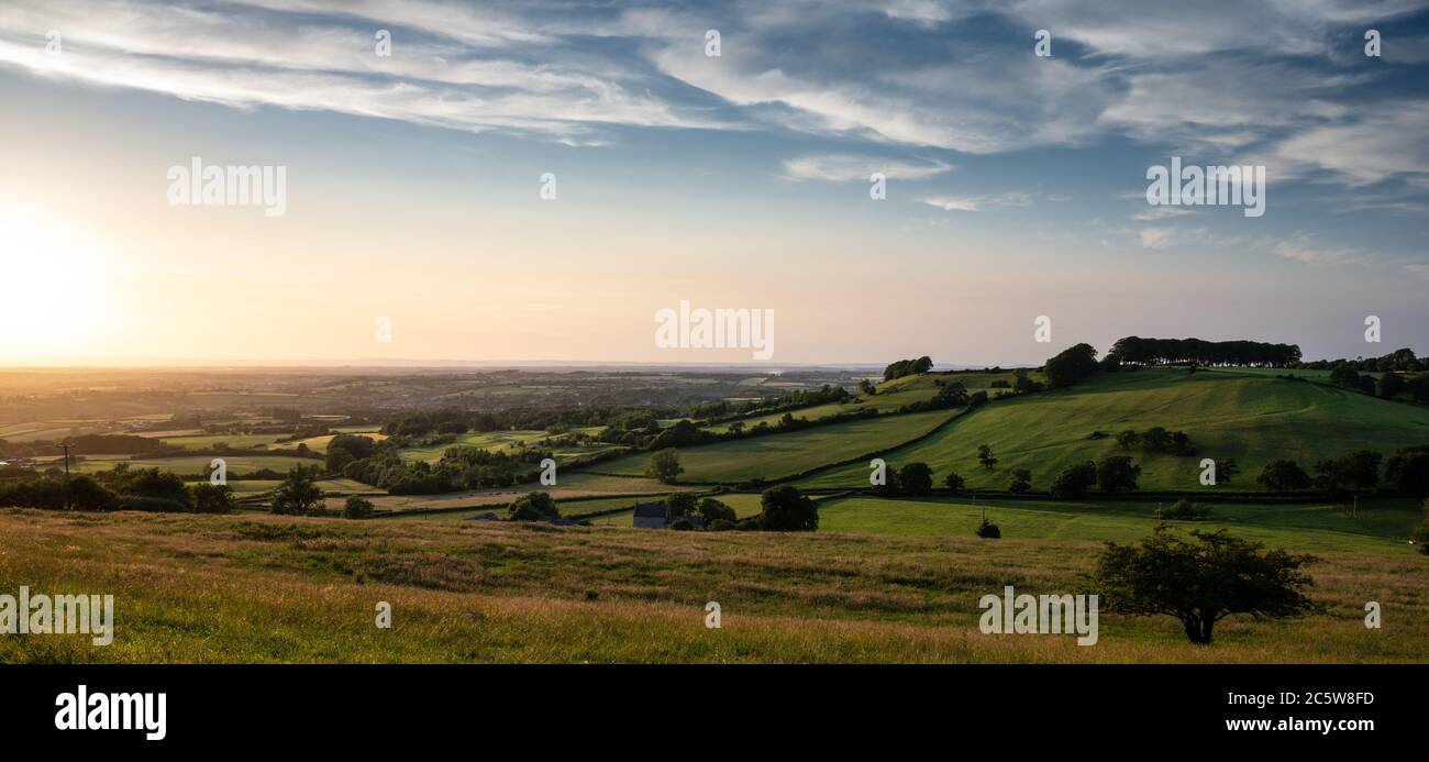 The setting sun casts a golden light over the agricultural landscape of the Golden Valley of South Gloucestershire under the scarp of the Cotswold Hil Stock Photo