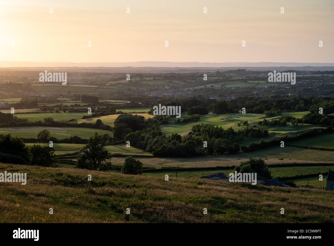 A patchwork of farmland fields, coppice woodland, villages and golf courses covers the lowland landscape of South Gloucestershire, below the scarp of Stock Photo