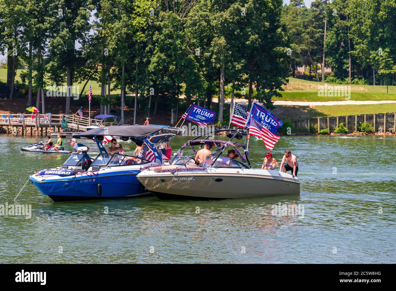 Mooresville, NC, USA - July 4, 2020: Luxury Boats flying Trump 2020 flags for President Donald Trump on Lake Norman near the Trump National Golf Club Stock Photo