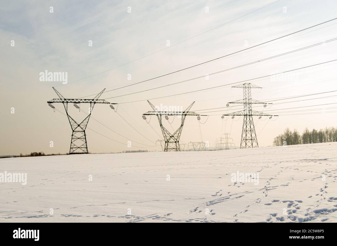 High voltage pylons in a clearing during winter Stock Photo - Alamy