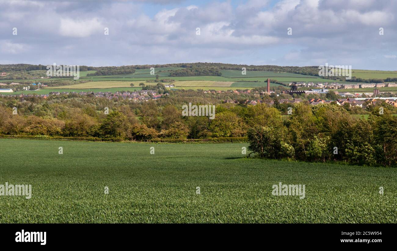 Houses of the town of Newtongrange, and the pit head equipment and chimney of Lady Victoria Colliery, are nestled in the Esk Valley in Midlothian. Stock Photo
