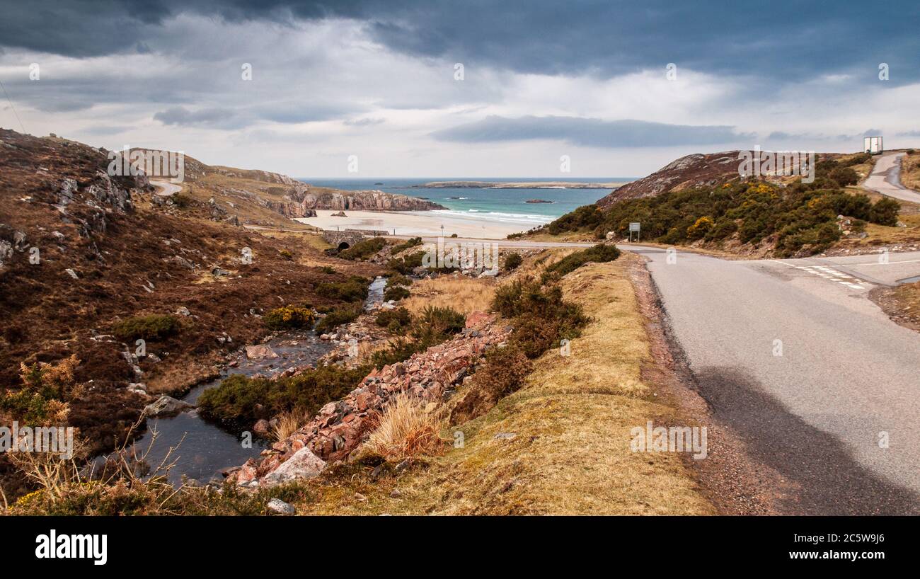 The A838 road, part of the North Coast 500 touring route, winds past sandy beaches near Durness on the far north of the Highlands of Scotland. Stock Photo