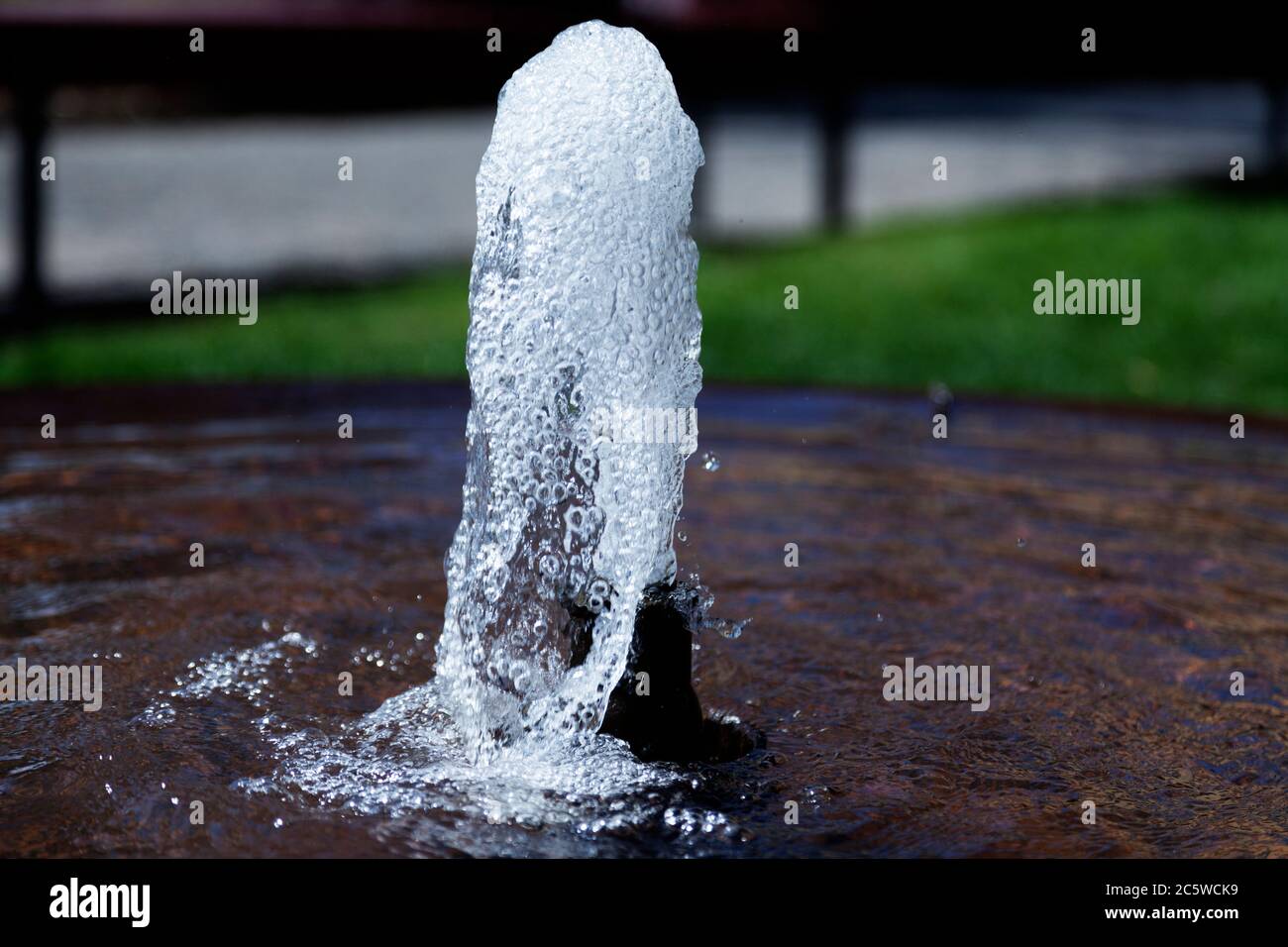 a small fountain in a park that bubbles Stock Photo Alamy