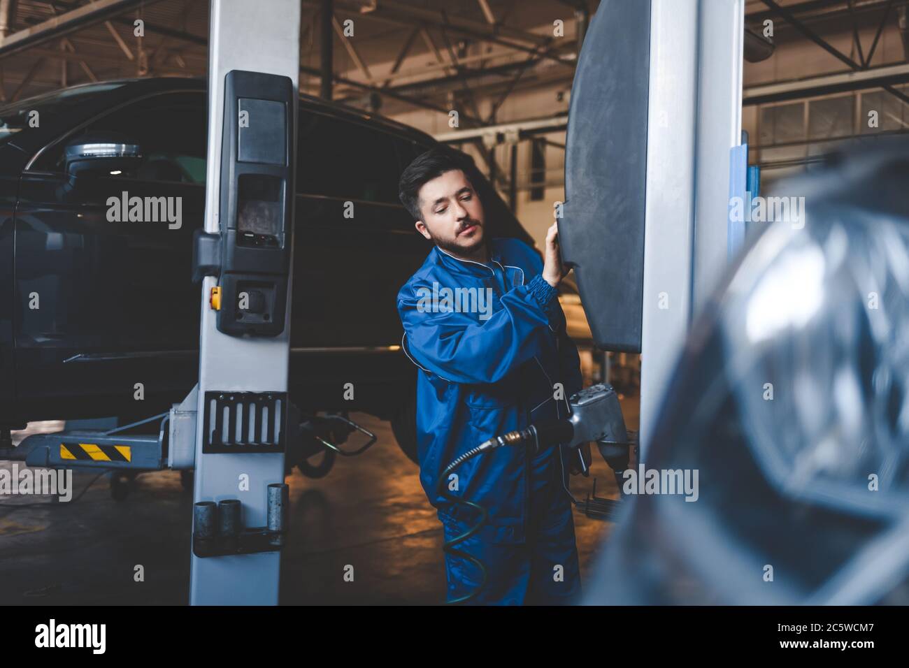 Auto mechanic lifts a car on a lift. Car repair Stock Photo Alamy