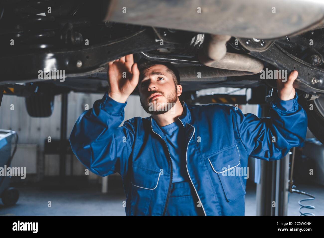 Auto mechanic inspects car suspension. Diagnostics of the condition of