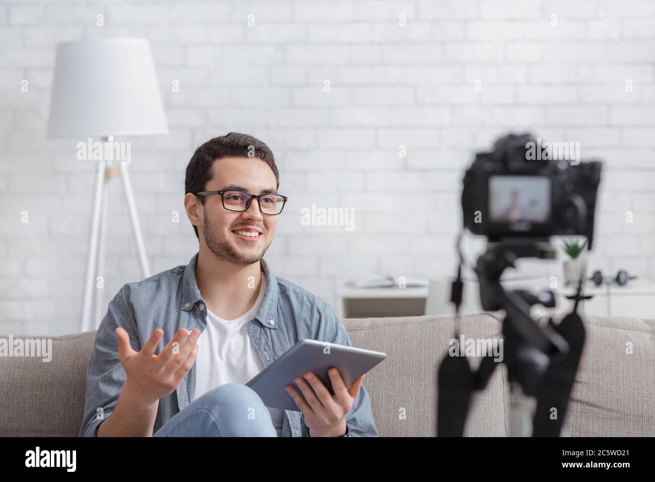 Streaming online podcast. Modern man with tablet makes recording video Stock Photo