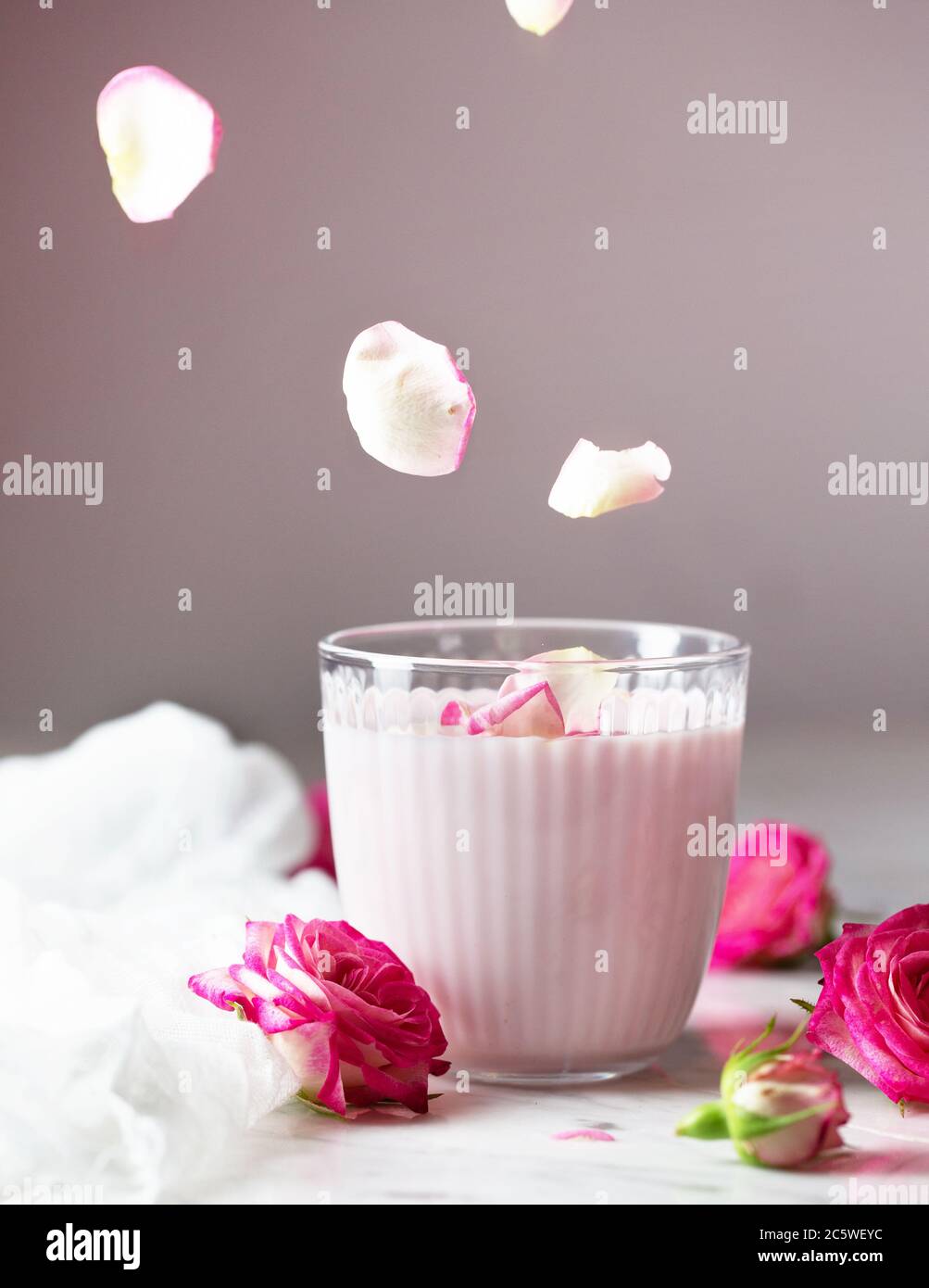 Moon milk prepares with pink rose flower. Trendy bedtime drink form Ayurvedic traditions Stock Photo