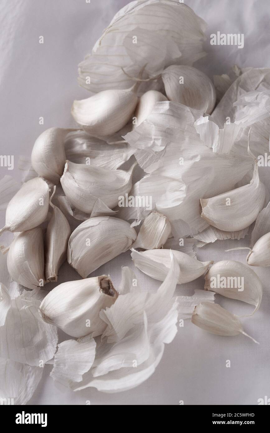 Garlic cloves scattered in a white background Stock Photo