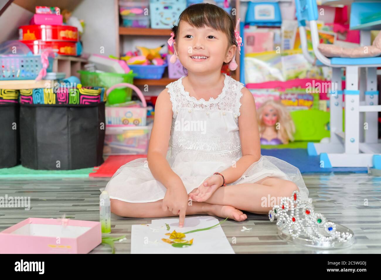 Child little girl play toys disorderly mess in living room a dirty or untidy state of toy and doll at home Stock Photo