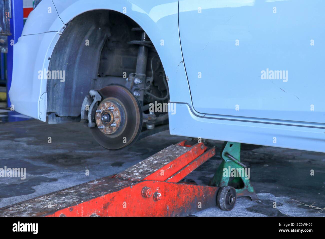 Replacing wheels on a car, jack holds the body in raised position Stock Photo